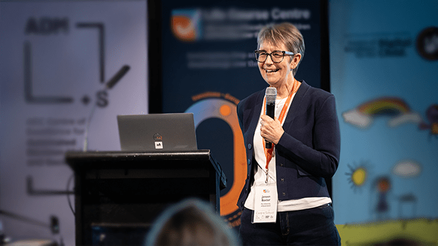Janeen Baxter holding a mic at an ARC Summit 2023