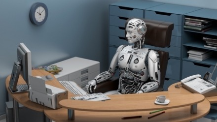 futuristic humanoid robot sitting relaxed in the office and watching his PC monitor. 